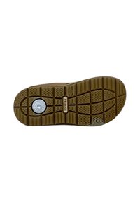 Suola di scarpa in gomma con un battistrada a motivo, caratterizzata da un dettaglio circolare ammortizzatore al tallone. I colori includono marrone e beige.