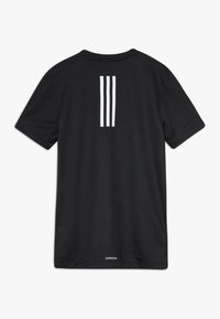 Svart t-shirt med kort ärm som har tre vertikala vita ränder på ryggen, med en slät textur och AEROREADY-logotyp nära fållen.