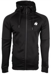 Felpa nera con zip realizzata in tessuto elasticizzato. Presenta una tasca a marsupio, un cappuccio con cordoncino e un piccolo logo sul lato sinistro del petto.