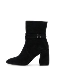 Botas de ante negras hasta el tobillo con punta afilada, caña baja y desenfadada, y dos correas decorativas con hebillas en el tobillo. Tacón cuadrado.