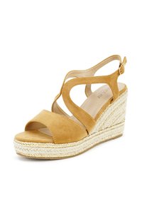 Suede wedge sandal in honey, featuring an open toe, crisscross straps, and woven jute midsole with metallic accents on the edge.