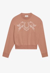 Rosa kort sweatshirt med lange ermer, prydet med hvit blomsterbroderi og en hestesko-design på fronten. Myk, teksturert stoff.