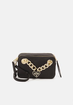 Sac bandoulière rectangulaire noir avec détail chaîne dorée et breloque en forme de cœur Versace Jeans Couture à l’avant.