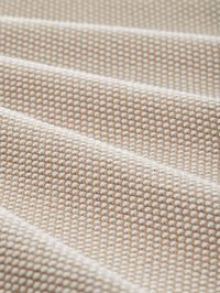 Tissu texturé beige et blanc avec un petit motif carré et des plis doux créant une surface ondulée.