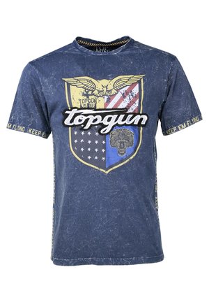 Granatowa koszulka z nadrukiem tarczy, na której znajduje się orzeł, paski i grafika lwa. Tekst zawiera "topgun" oraz "KEEP EM FLYING". Efekt przetarcia.