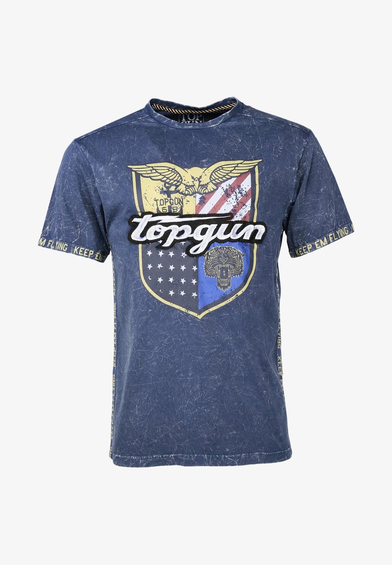 Granatowa koszulka z nadrukiem tarczy, na której znajduje się orzeł, paski i grafika lwa. Tekst zawiera "topgun" oraz "KEEP EM FLYING". Efekt przetarcia.