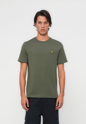 T-shirt en coton vert olive avec des manches courtes, un col rond et un petit logo jaune brodé sur la poitrine gauche. Design simple.