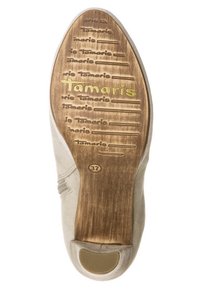Beige shoe sole with textured wood finish, featuring embossed lettering "Tamaris" and size 37. Rounded toe design with rubber accent.