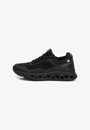 Zapatillas deportivas negras con parte superior de malla, cuello acolchado, diseño de cordones y suela esculpida con recortes hexagonales para ventilación.