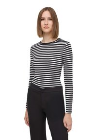 Camicia a maniche lunghe a strisce bianche e nere con scollatura rotonda, design aderente e texture liscia; abbinata a pantaloni neri a gamba dritta.