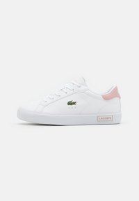 White sneakers with a smooth synthetic upper, pink heel accents, and a green embroidered crocodile logo. Features flat laces and a rubber sole.