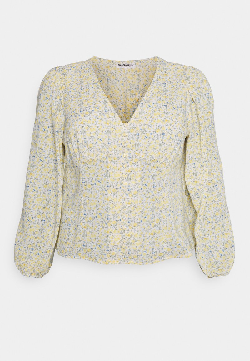 Blusa floral em tons de amarelo e azul com decote em V, mangas balão longas e detalhes franzidos. Tecido leve com uma textura suave.