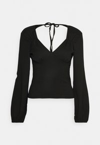 Svart långärmad topp med V-ringning, figurnära silhuett, lätt texturerad tyg, och knytdetalj bak. Puffärmar som smalnar av vid handlederna.