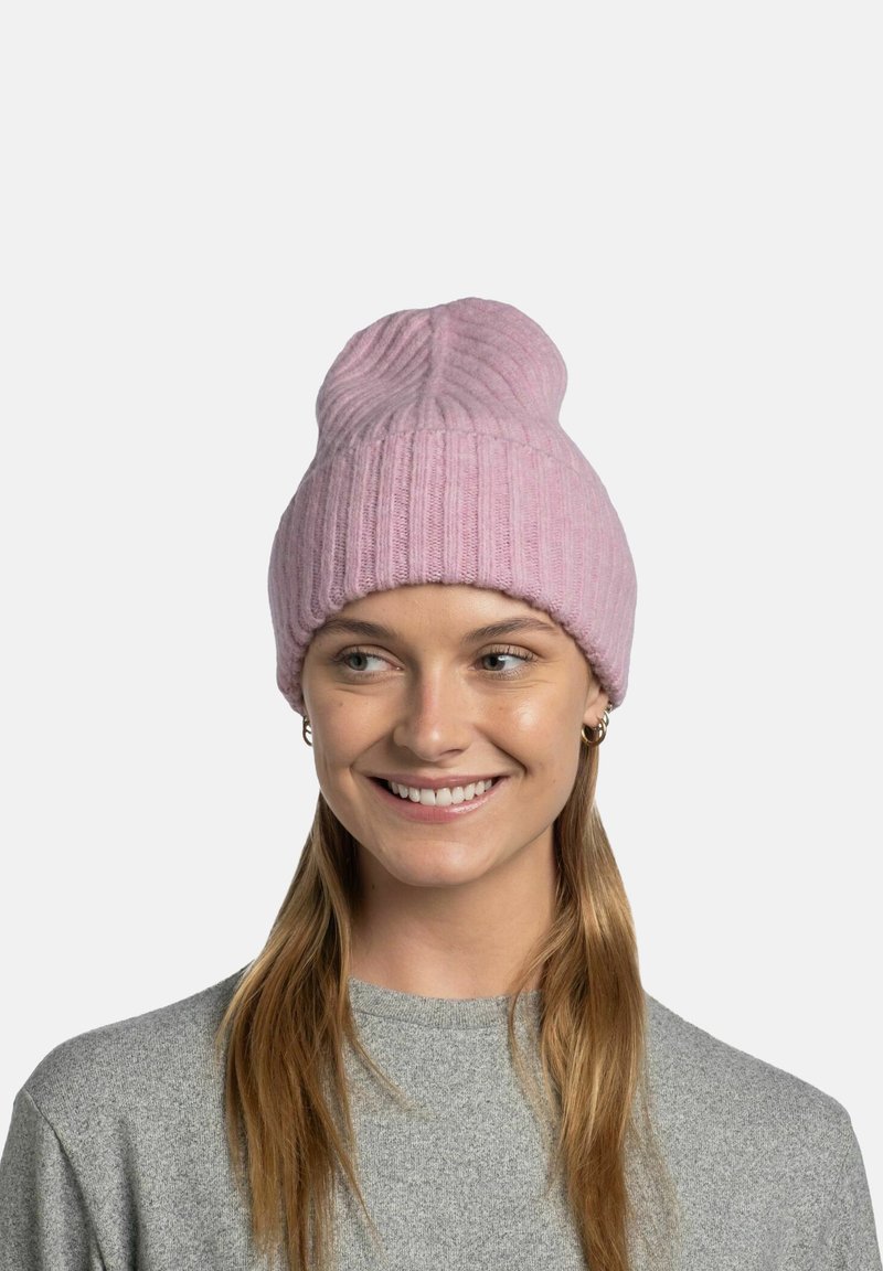 Pink knit beanie with a ribbed texture, featuring a rolled edge and a rounded top, worn by a person with long hair.