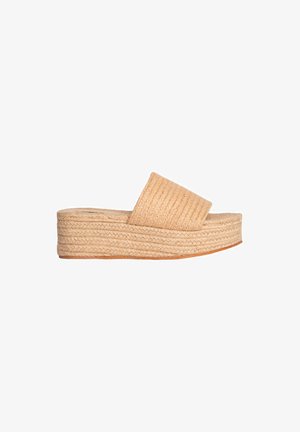 Sandalia de plataforma trenzada en color beige con una correa texturizada, material similar a yute y una suela gruesa, que cuenta con una parte inferior marrón suave.