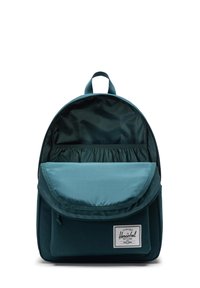 Sac à dos teal avec une forme arrondie, fabriqué en tissu texturé. Il dispose d'une fermeture par rabat, d'une poche avant et d'un compartiment intérieur.