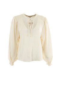 Blusa de manga larga crema con hombros recogidos, escote delantero con lazo y puños elásticos, confeccionada en una tela texturizada ligera.