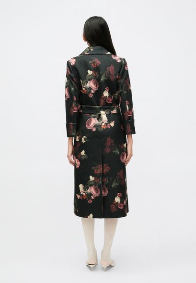 Mustast kangast pikem mantel lillemustriga, mis sisaldab burgundi, koorevalget ja rohelist tooni; vööga talje, sälguga krae ja mansettidega varrukad.