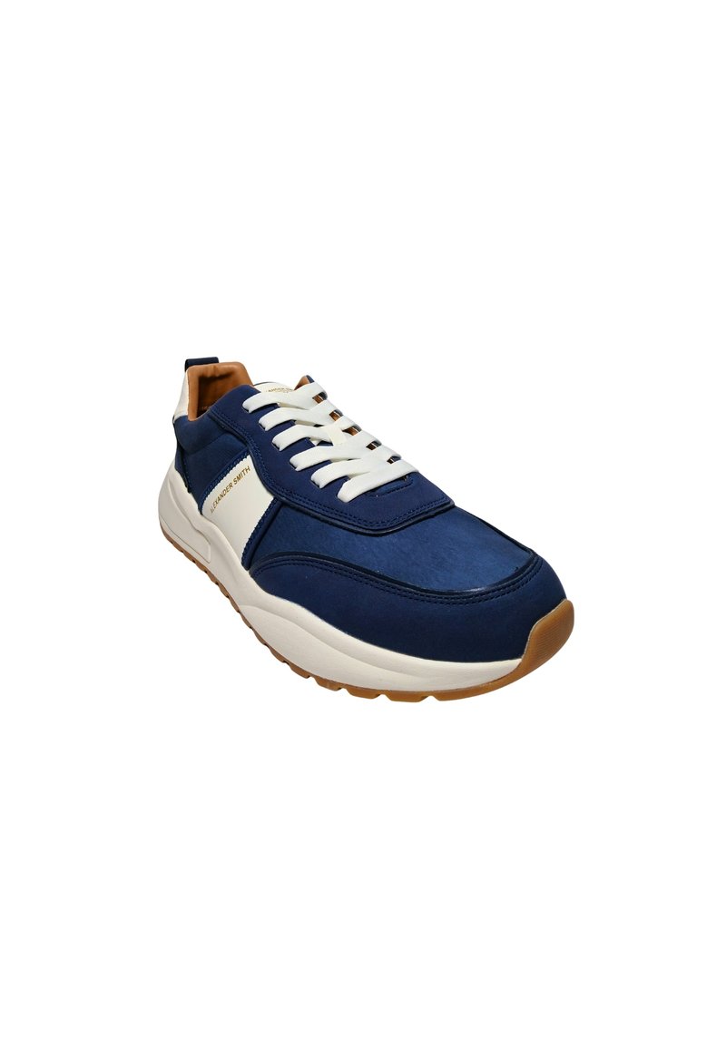 Scarpa da ginnastica atletica blu navy con lacci bianchi, texture liscia e design semplice. Presenta una suola in gomma marrone e accenti contrastanti.