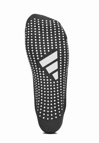 Calcetín de silicona negro con un patrón de puntos blancos en la suela y un logo triangular blanco. Presenta un diseño ajustado y un agarre texturizado.