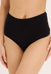 Mutande nere a vita alta realizzate in tessuto morbido, con bordi lisci e design a piena copertura, ideali per comfort e uso quotidiano.
