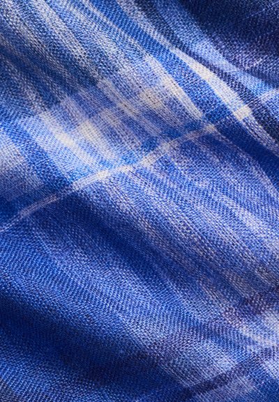 Μπλε και λευκό υφαντό ύφασμα με υφή, ελαφρώς ζαρωμένη επιφάνεια σε κοντινή άποψη.