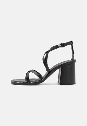 Black heeled sandals with a square toe, featuring multiple narrow straps, an adjustable ankle buckle, and a textured block heel.
