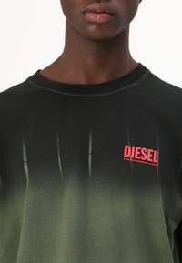 Czarny i zielony gradientowy t-shirt wykonany z bawełny, z okrągłym dekoltem, krótkimi rękawami i czerwonym logo "DIESEL" na piersi.