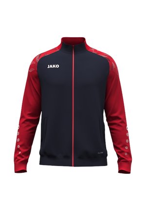 Marineblaue und rote Sportjacke mit durchgehendem Frontreißverschluss, roten Ärmeln mit weißen Punkten und JAKO-Logo auf der linken Brust.