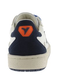 Sneaker da uomo con tomaia in pelle bianca, dettagli in suede blu navy, logo arancione sul tallone, suola in gomma beige texturizzata e interno imbottito.