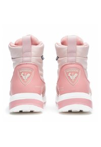 Różowe zimowe buty z podszewką, wykonane z gładkich i teksturowanych materiałów, z białymi podeszwami i wytłoczonym logo na pięcie. Posiadają pętelkę na tylnej części.