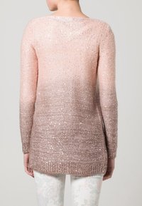 Långärmad rosa gradienttröja med en texturerad, glittrig finish. Mjukt stickat material som övergår från ljusa till mörka nyanser vid nederkanten.
