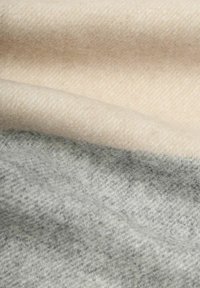 Wolmixstof met een naadloze overgang van licht beige naar zacht grijs, met een gladde textuur en een subtiel geweven patroon.