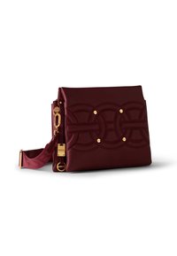 Burgundy leather crossbody bag with quilted circular patterns and gold hardware, including a detachable adjustable strap.