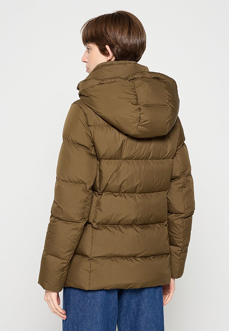 Olivegrüne gepolsterte Jacke mit Kapuze, mit horizontalen Nähten, einem lockeren Schnitt und einer glatten Textur.