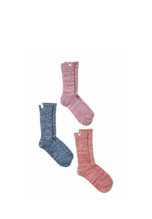 Tre enkeltstrikkede sokker i blå, pink og rød farve arrangeret på en hvid baggrund.