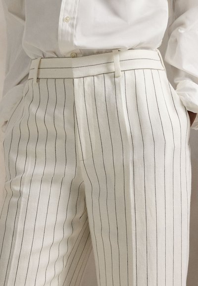 Λευκό παντελόνι με λεπτές μαύρες ρίγες, με εφαρμοστή γραμμή και ομαλή υφή. Διακριτικές θηλιές ζώνης στη μέση.