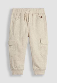 Béžové dětské tepláky s elastickým pasem, stahovací šňůrkou, bočními kapsami s klopami a žebrovanými lemy.