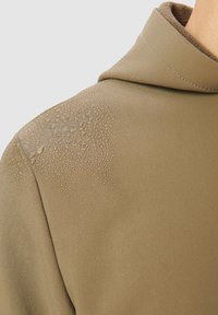 Bluza z kapturem w oliwkowozielonym kolorze, wykonana z teksturowanej tkaniny, z kropelkami wody na ramieniu i miękką brązową podszewką.