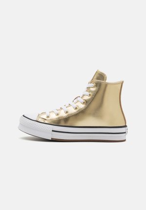 Højtop-sneaker med skinnende metallic guld overdel, hvid gummitåhætte, hvide snørebånd og hvid sål med sorte striber.