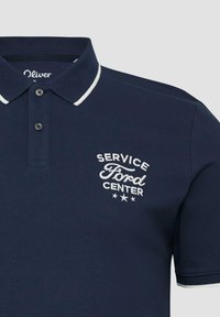 Marineblauwe polo met witte bies op de kraag en mouwen, twee knopen, en witte geborduurde tekst "Service Ford Center" met drie sterren.