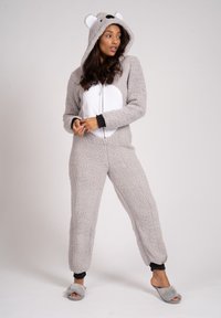 Grijze fleec Onesie met een witte buik, berenoren op de capuchon, voorrits, ribgebreide manchetten en bijpassende grijze slippers met een zachte textuur.