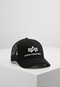 Svart baseballcaps med netting bak. Har hvit "ALPHA INDUSTRIES" tekst og grafisk logo. Bøyd skjerm, fem-panel design, justerbar stropp.