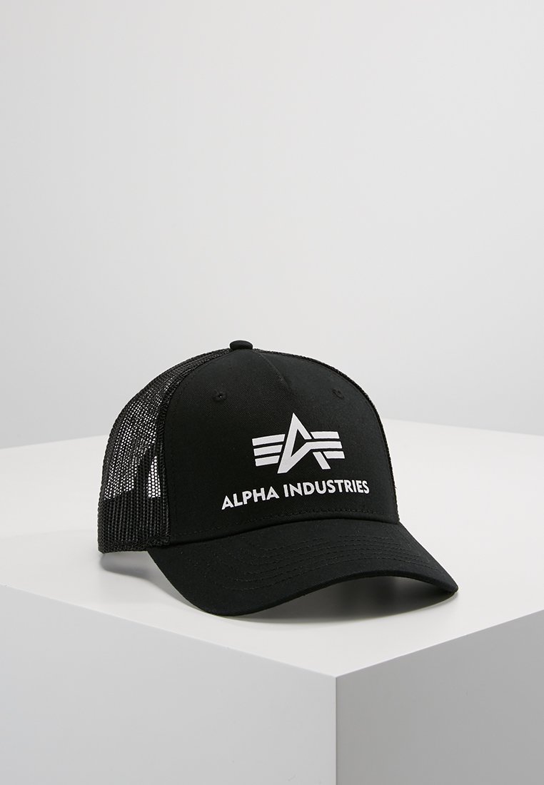 Svart baseballcaps med netting bak. Har hvit "ALPHA INDUSTRIES" tekst og grafisk logo. Bøyd skjerm, fem-panel design, justerbar stropp.