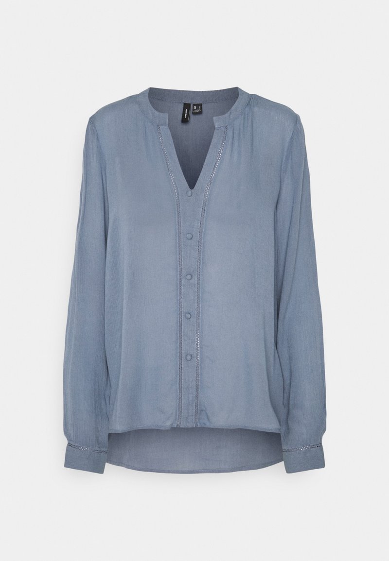 Blouse bleu clair à manches longues, boutonnée sur le devant, col mandarin, avec des détails de couture subtils le long de la patte de boutonnage et des poignets.