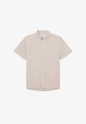 Trumpa rankovė, šviesiai smėlio spalvos marškiniai, pagaminti iš tekstūruotos medžiagos, su mygtukų užsegimu priekyje ir subtiliu siuvinėtu logotipu ant krūtinės.