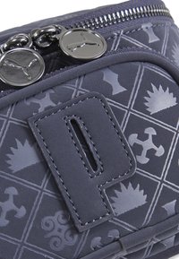Navy blue soft material bag with geometric patterns, featuring a prominent logo patch and zipper hardware with circular pulls.