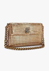 Metaliczna brązowa torebka na ramię z łańcuszkiem, pokryta okrągłymi cekinami, z ozdobnym zapięciem w kształcie muszli.