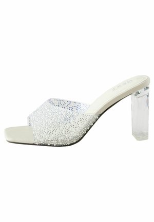 Sandalino open-toe bianco con un cinturino testurizzato decorato con strass e tacco a blocco trasparente. Suola liscia con forma della punta arrotondata.