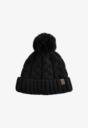 Schwarze Strickmütze mit einem strukturierten Zopfmuster, geripptem Bündchen und einem flauschigen Pompon oben. Mit einem kleinen brandisierten Lederpatch.